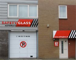 Het pand van Safety Glass aan <?= h($g['straat']) ?> in <?= h($g['plaats']) ?>, met rode luifels en bedrijfsnaam op de gevel